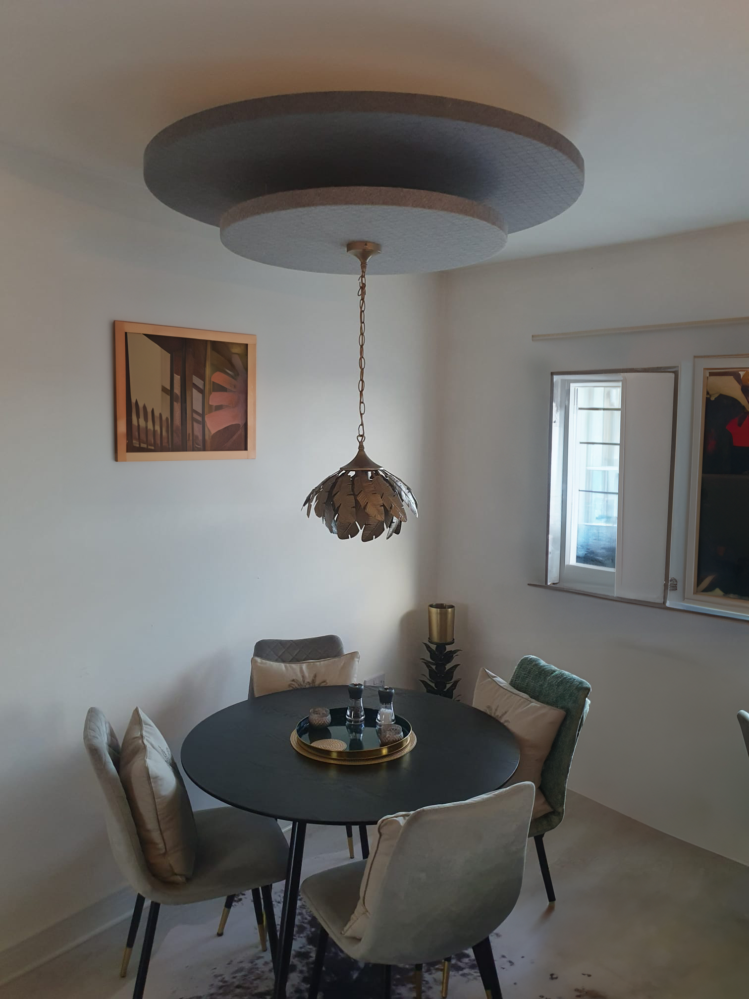 Acoustic ceiling panels with a lighting feature suspended over a dining table in a restaurant 