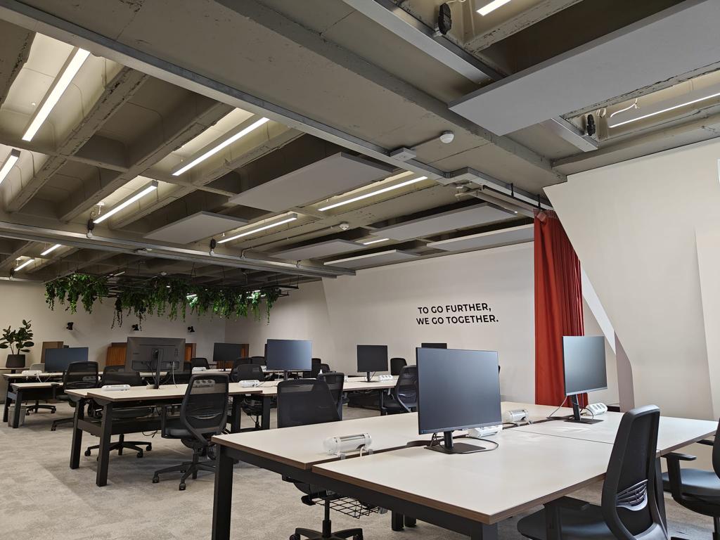 Grey suspended acoustic ceiling panels in an open plan office